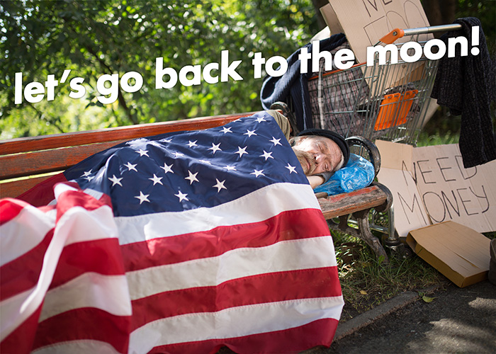 A blond bearded man lies asleep on a park bench with a back-to-front American flag as a blanket. Two large cardboard signs say 'need money' and 'need food'. A shopping cart sits behind him containing a large bag with a sweater on top. Angled text at the top reads 'let's go back to the moon'.